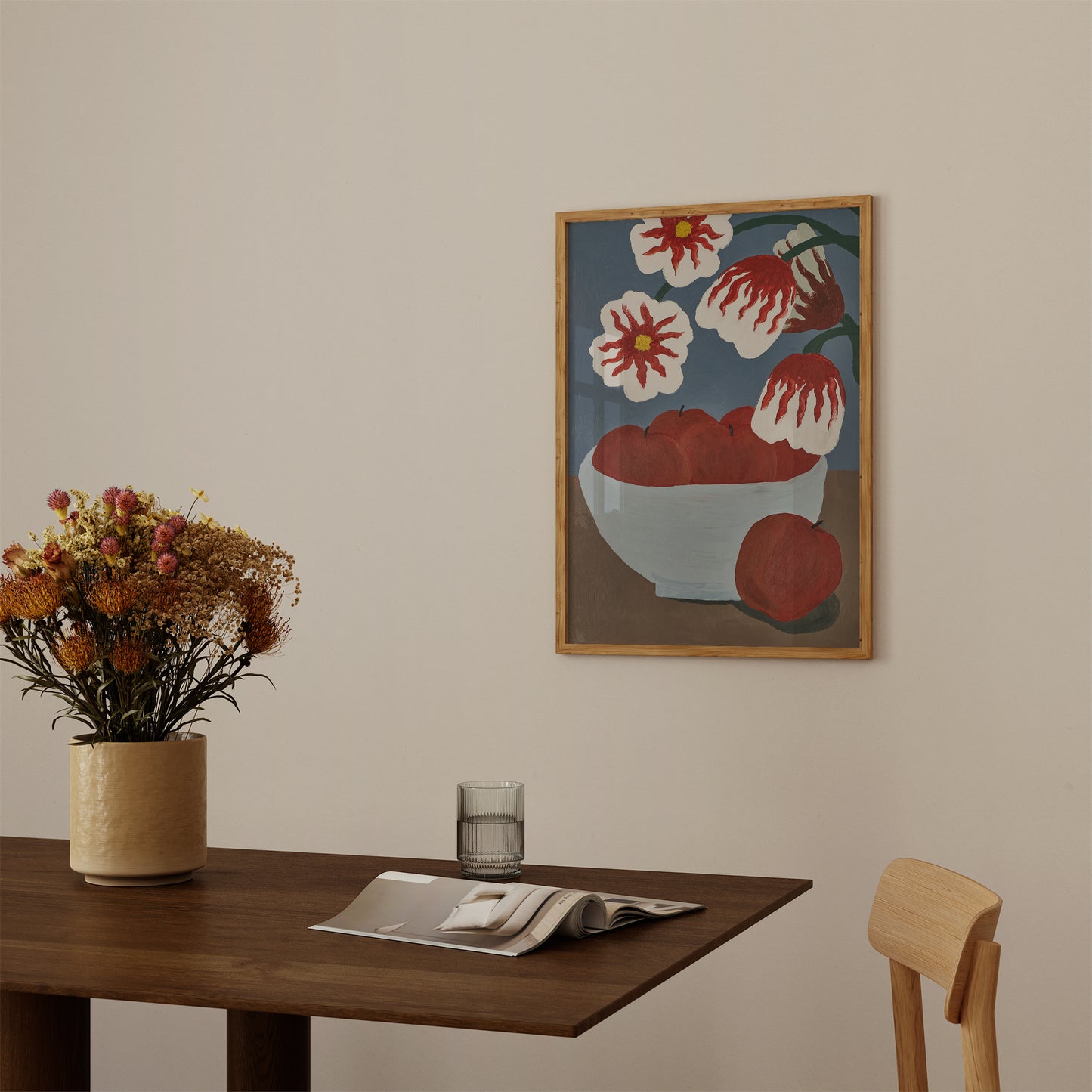 Framed acrylic painting art print of apples and flowers hanging in a minimalist dining room – modern still life wall art for kitchen or dining area decor.