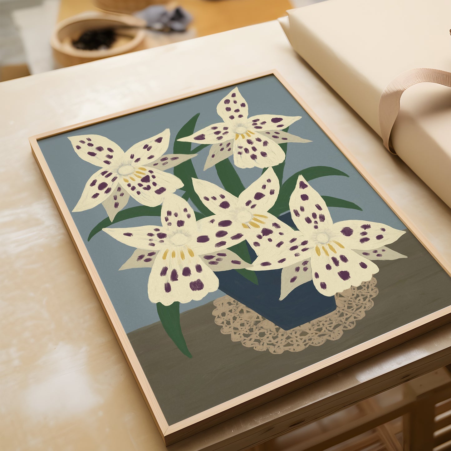 White flowers illustration laying on a wooden surface – botanical art print with blue background and cream flowers, ideal for floral wall decor.