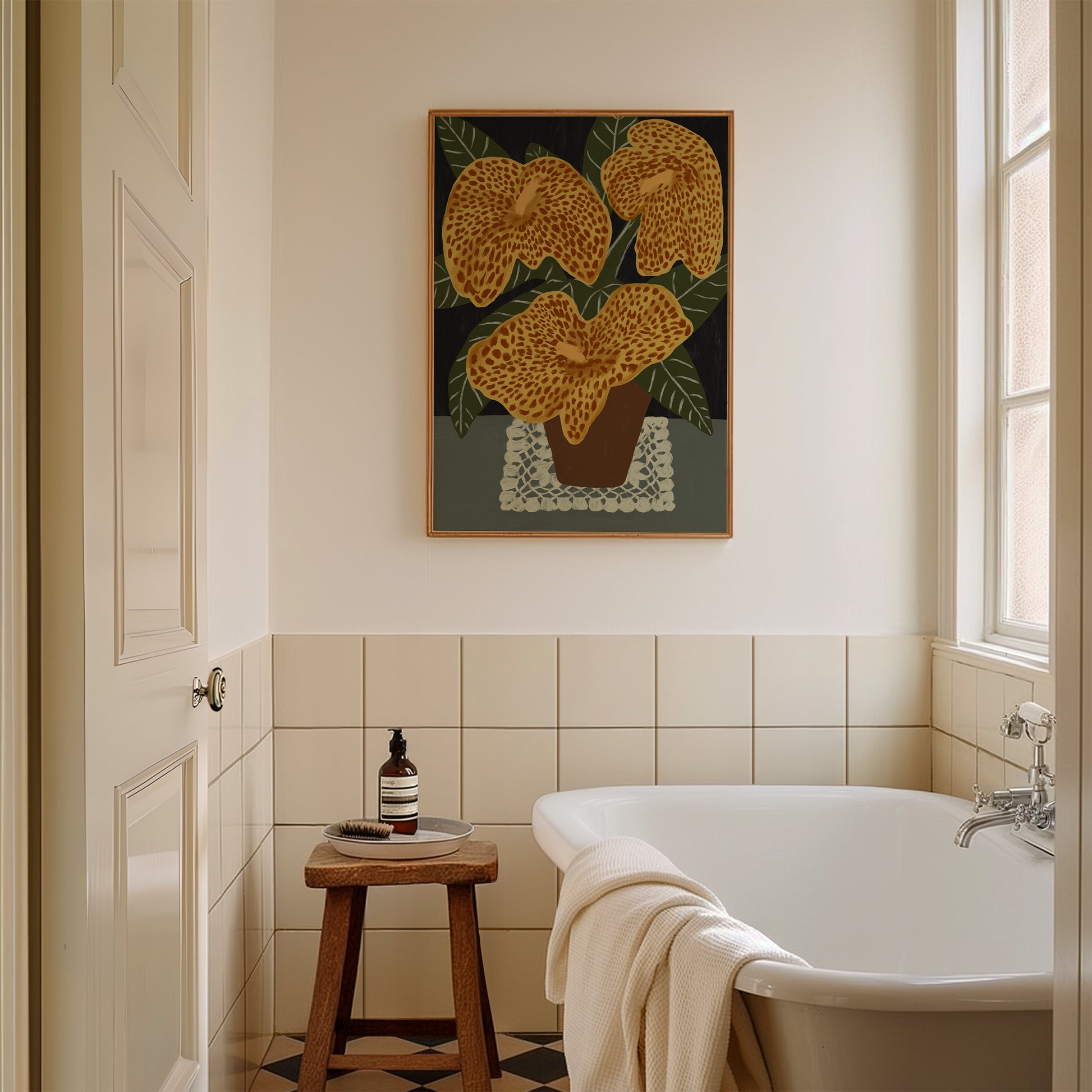 Framed golden lilies illustration art print hanging in a bright bathroom – elegant floral wall art for spa-inspired or botanical home interiors.