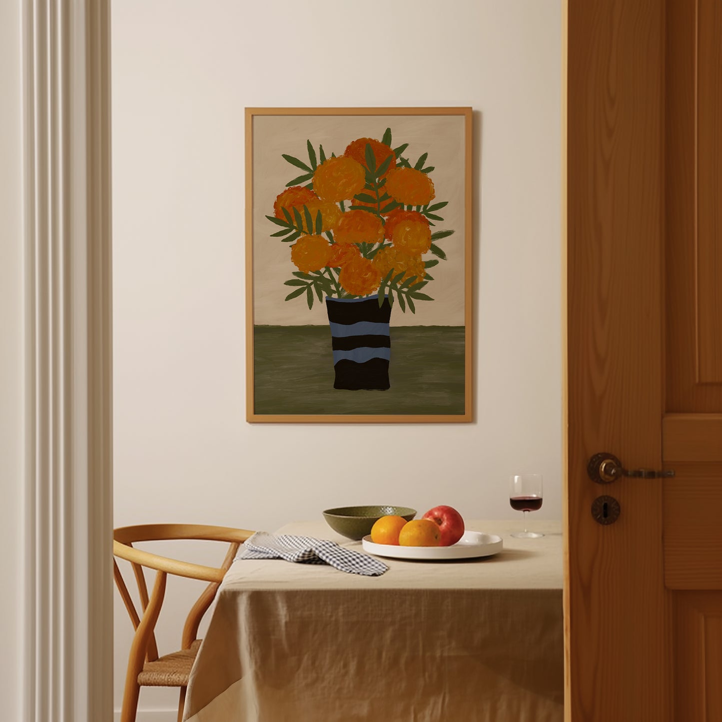 Framed marigold flower art print displayed in dining nook, contemporary floral wall art for kitchen or dining room décor.