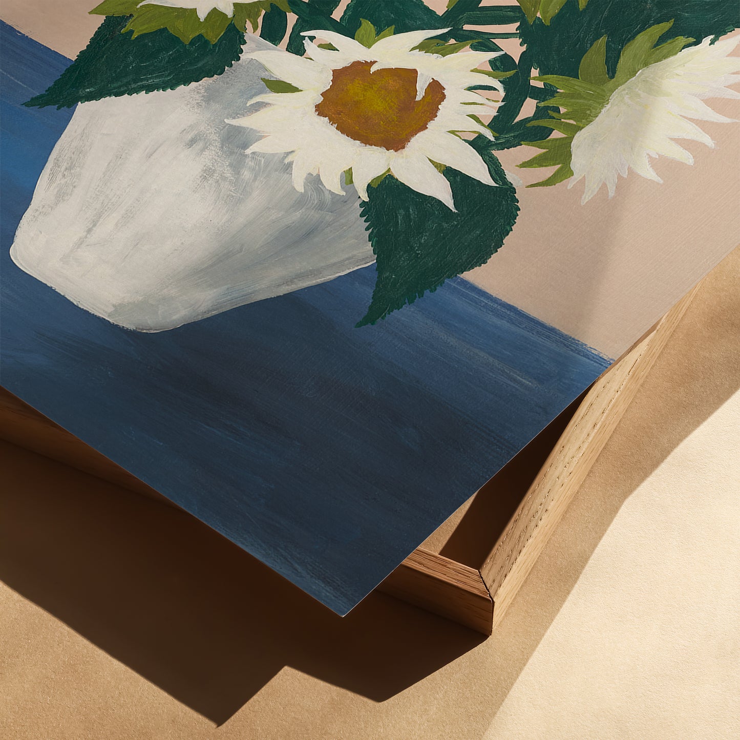 Close-up of sunflower still life art print showing white vase and green leaves on blue tabletop. Modern floral wall decor with fine-art painterly texture.